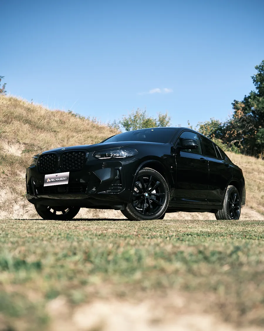 SUV nero fotografato su un prato al sole